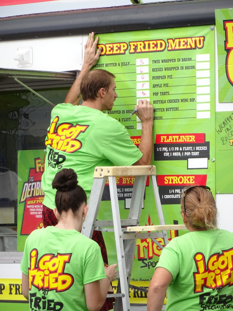 Workers put the finishing touches on the menu at Fried Specialties. 